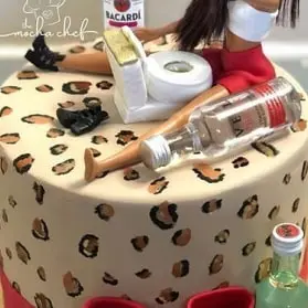 A cake with a woman sitting on top, celebrating a Bachelorette Party